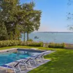 This Duxbury landscape pairs a stone pool terrace with layered coastal planting while preserving open water views.