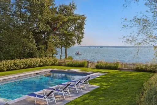 Stone pool terrace with layered coastal planting and open water views in Duxbury.