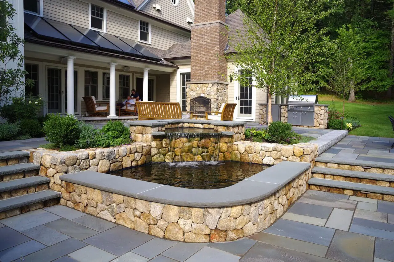 A thoughtfully integrated water feature adds gentle movement and sound to the outdoor living space, enhancing the atmosphere without overwhelming the surrounding landscape.
