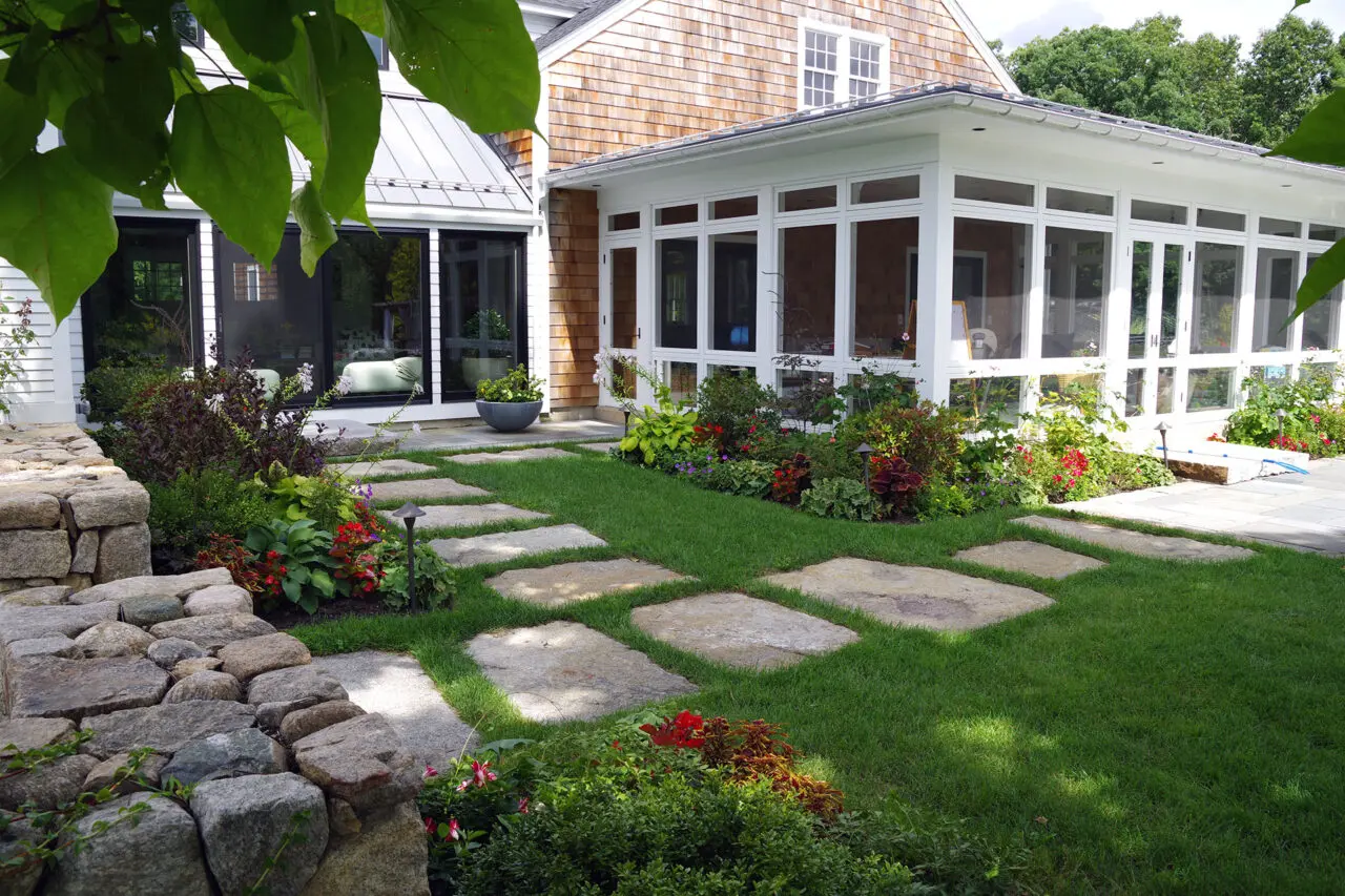 Granite stepping stones cross the lawn, offering subtle circulation without interrupting the open landscape.