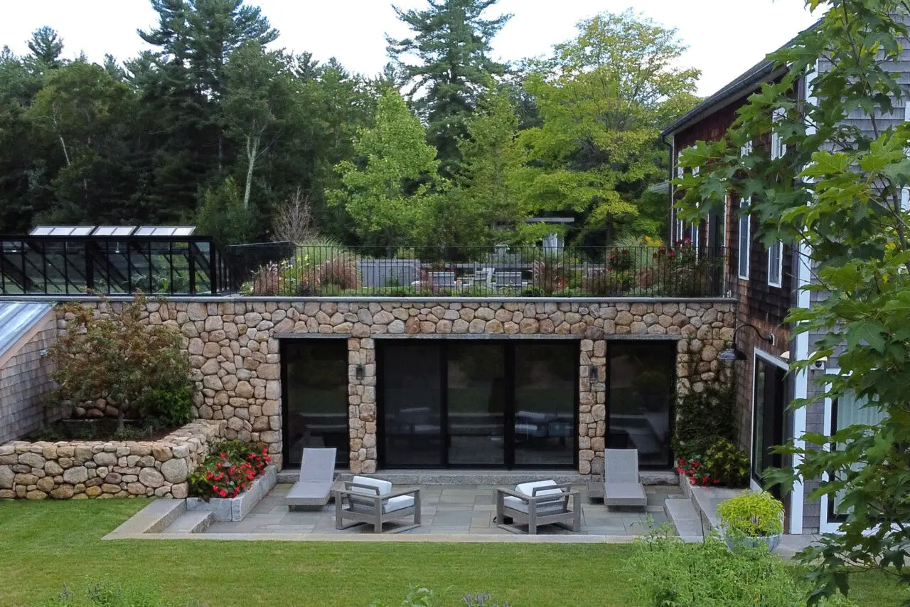 Stone walls shape a sheltered seating zone, emphasizing comfort, scale, and connection to surrounding gardens. 1