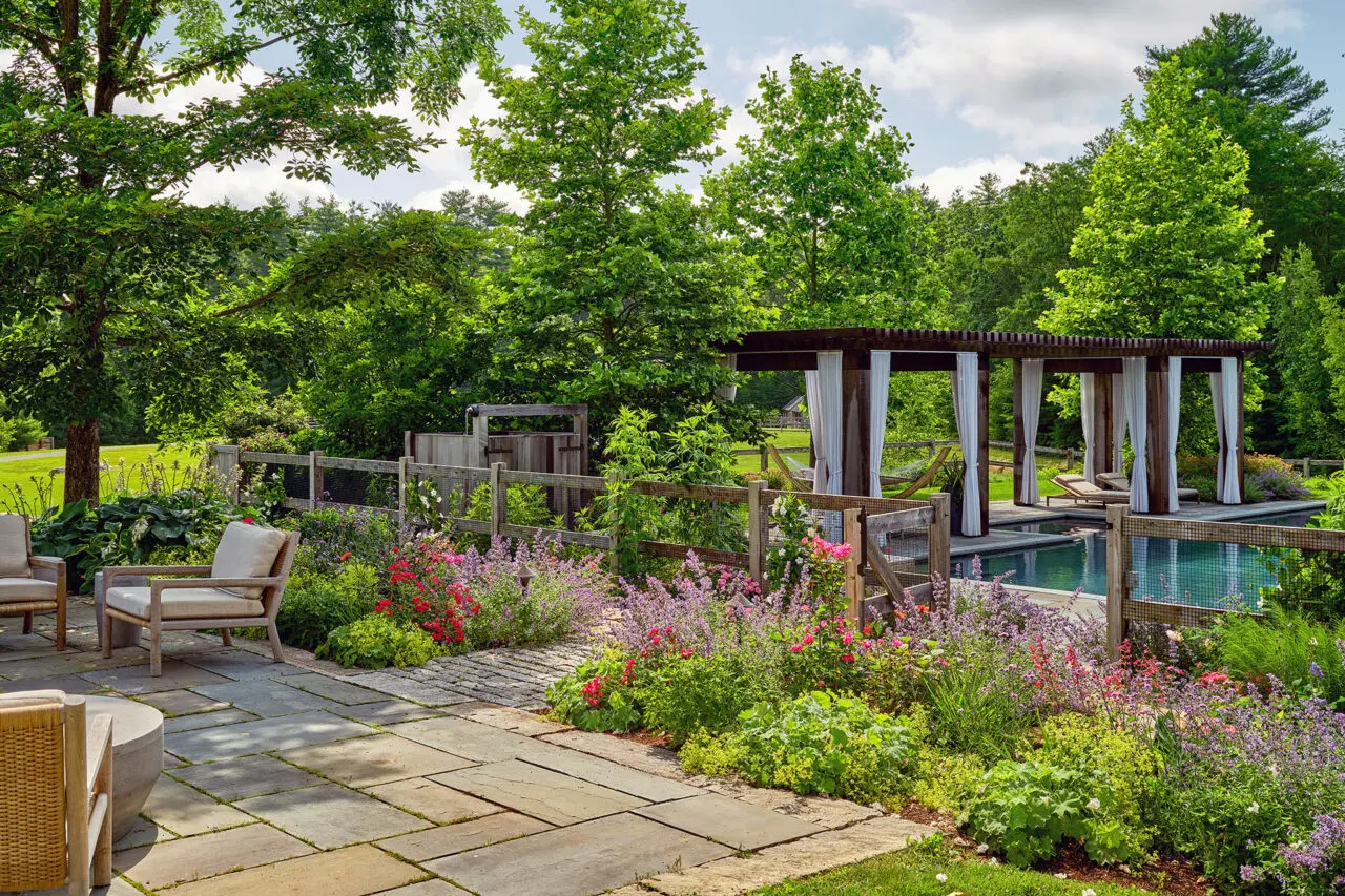 A pergola aligns with the pool’s axis, creating reflection, balance, and a strong visual focal point within the broader landscape.