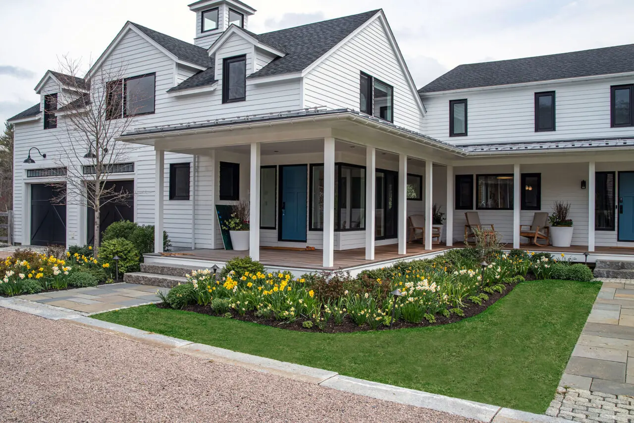 Foundation plantings and paths wrap the porch, creating a welcoming transition between home and garden.