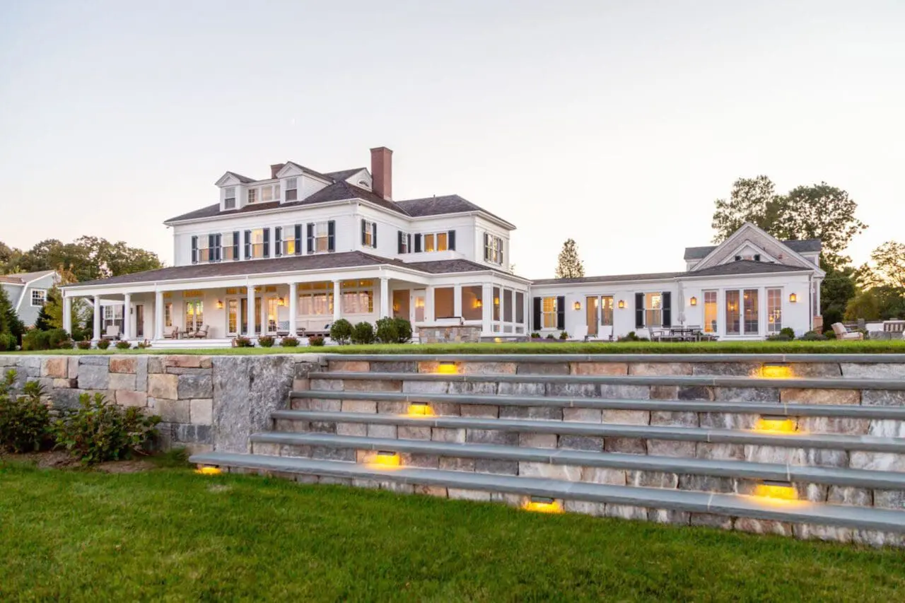 A natural stone pool terrace overlooking the coastal landscape in Duxbury, MA, where carefully layered plantings and elegant hardscape create a refined outdoor living space suited to South Shore properties.