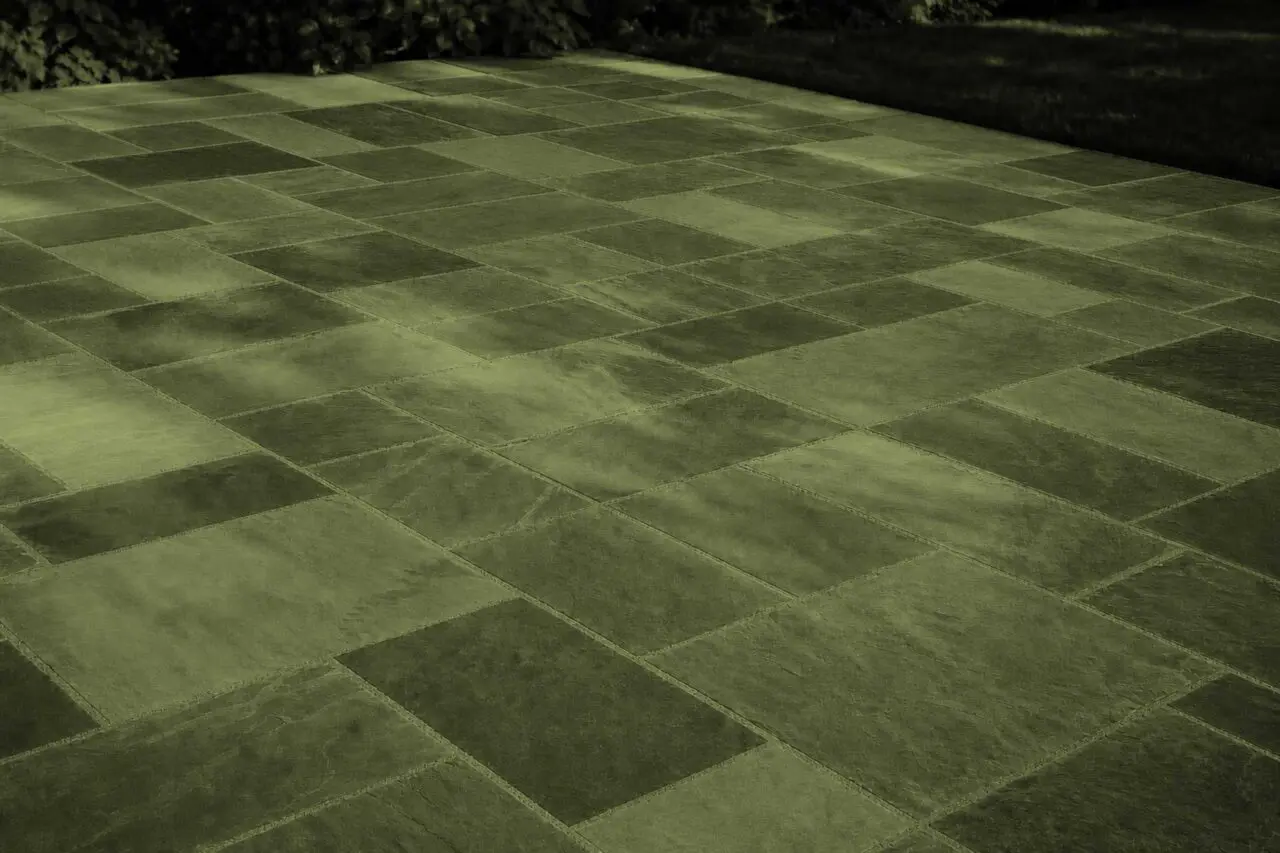 Belmont, MA - This dry-laid bluestone patio shows how frost heave, poor drainage, or an unstable base can cause individual stones to lift, sink, or rock after winter.