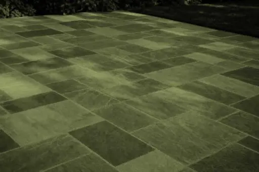 Belmont, MA - This dry-laid bluestone patio shows how frost heave, poor drainage, or an unstable base can cause individual stones to lift, sink, or rock after winter.