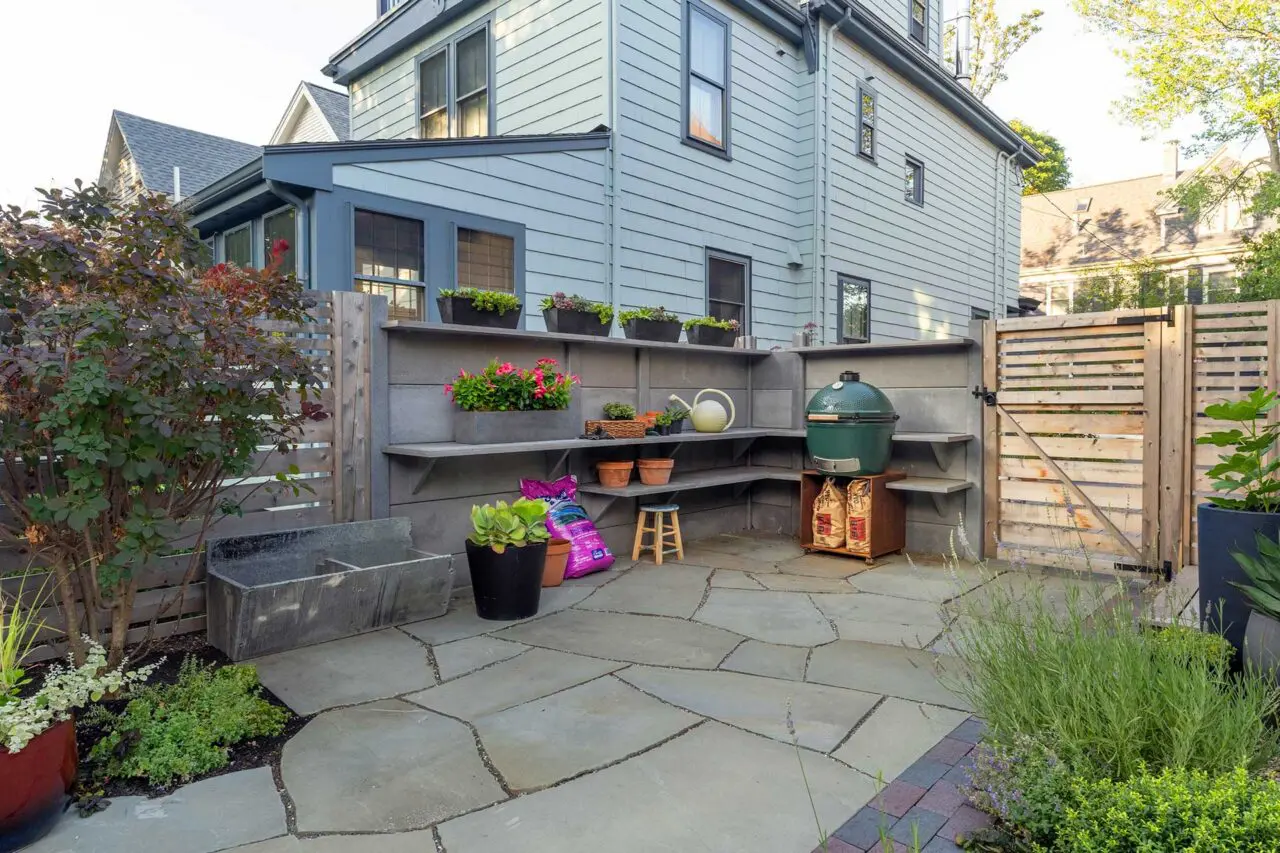 A built-in outdoor prep station integrates cast concrete walls and cedar fencing, forming a defined workspace that supports cooking and entertaining.