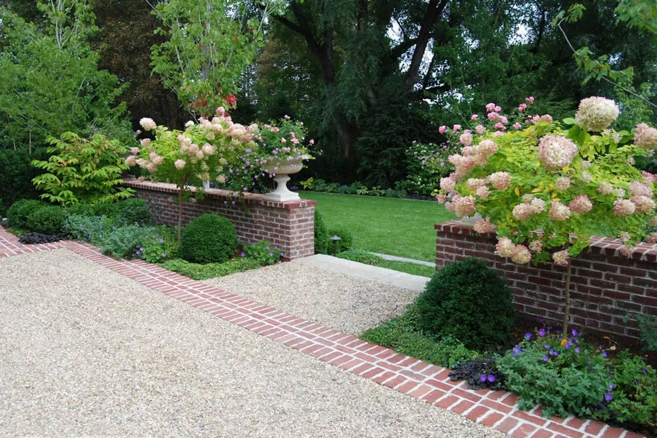 pea stone driveway with brick walls and planters