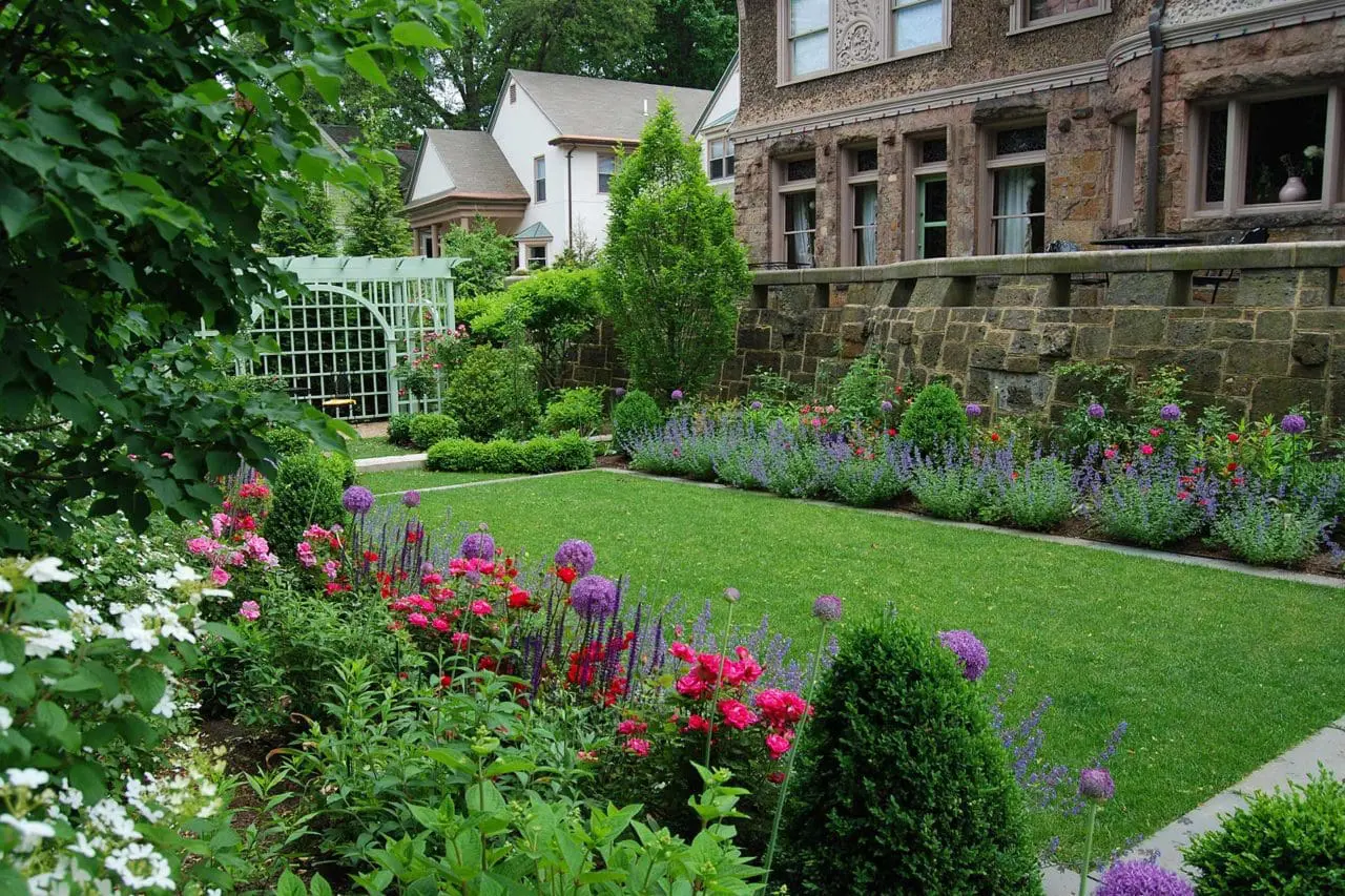 Brookline, MA - A mixed border of bulbs, perennials, and flowering and evergreen shrubs help to define an emerald green lawn.