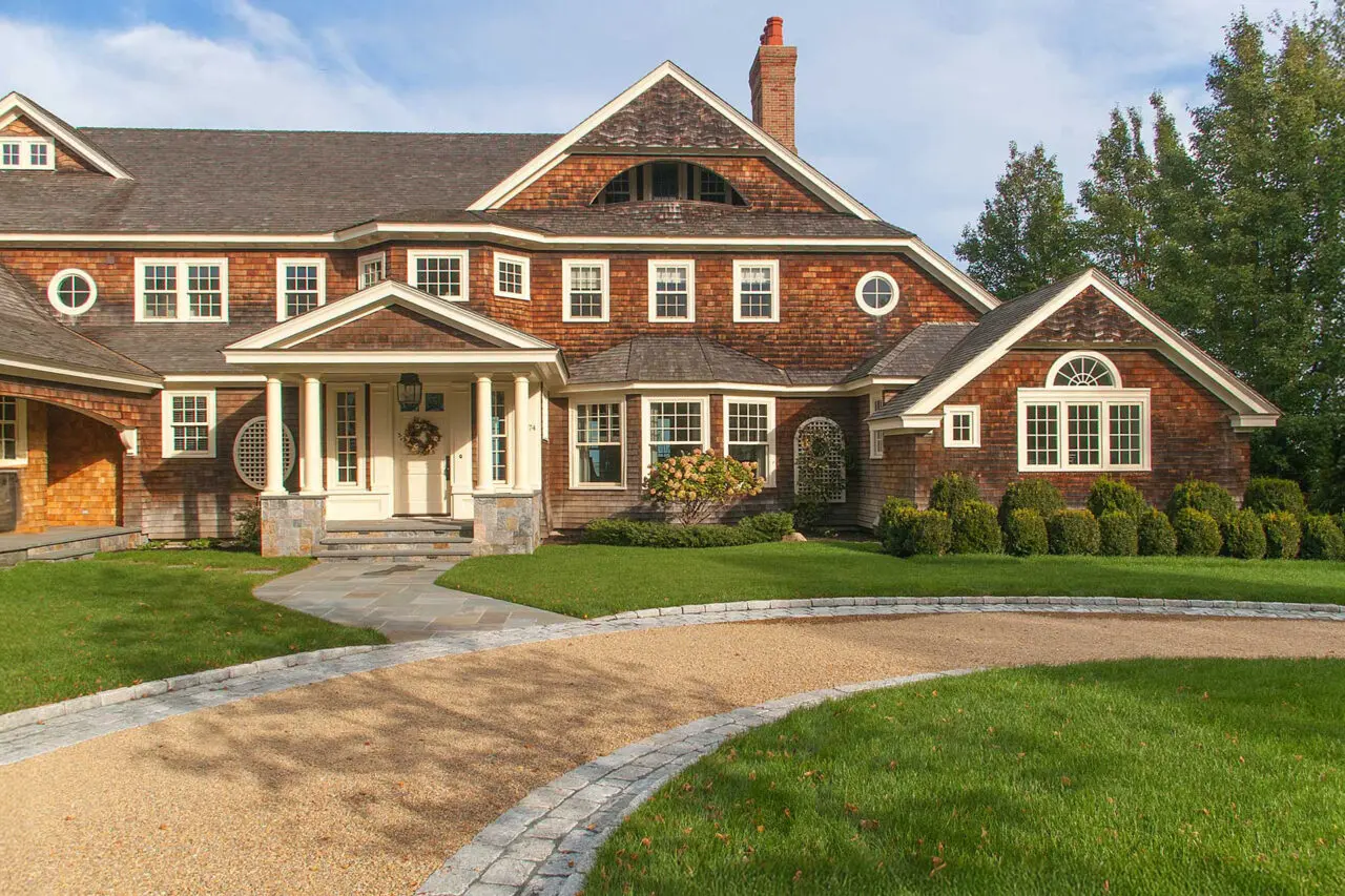 This circular gravel driveway in Duxbury, MA creates an elegant arrival court, with stone edging that defines the form and supports smooth circulation for guests and service vehicles.