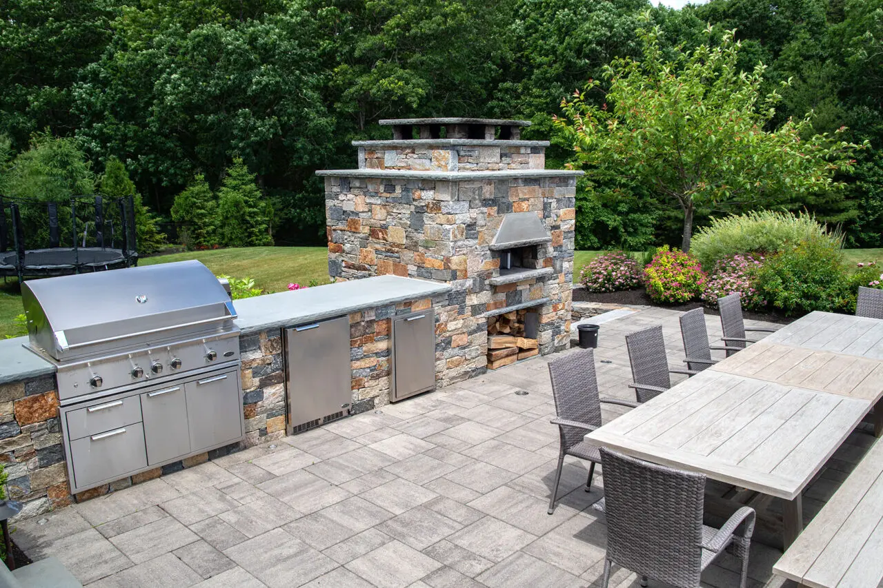 Designer-built gas grill integrated into stonework, creating a refined outdoor kitchen and dining experience.