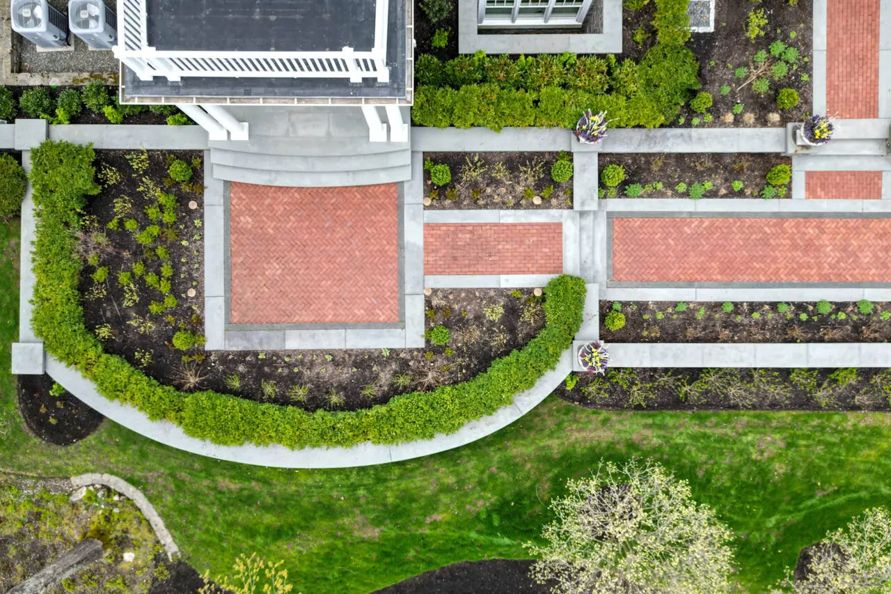 Aerial view highlights the structure and symmetry of a formal brick and bluestone garden walkway.