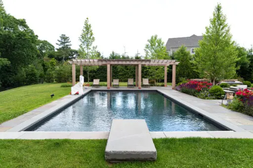 A geometric pool paired with a linear pergola and bluestone terrace, reinforcing modern design principles through repetition, structure, and clean transitions.