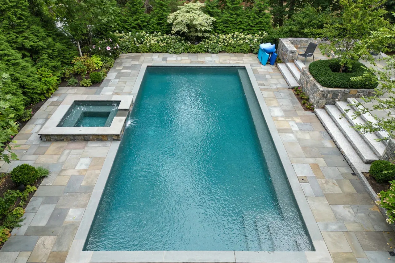 A linear rectangular pool set within a stone terrace and layered planting, using alignment and proportion to anchor the landscape in Lincoln.