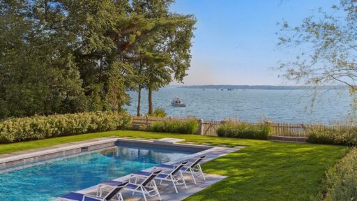 Stone pool terrace with layered coastal planting and open water views in Duxbury.