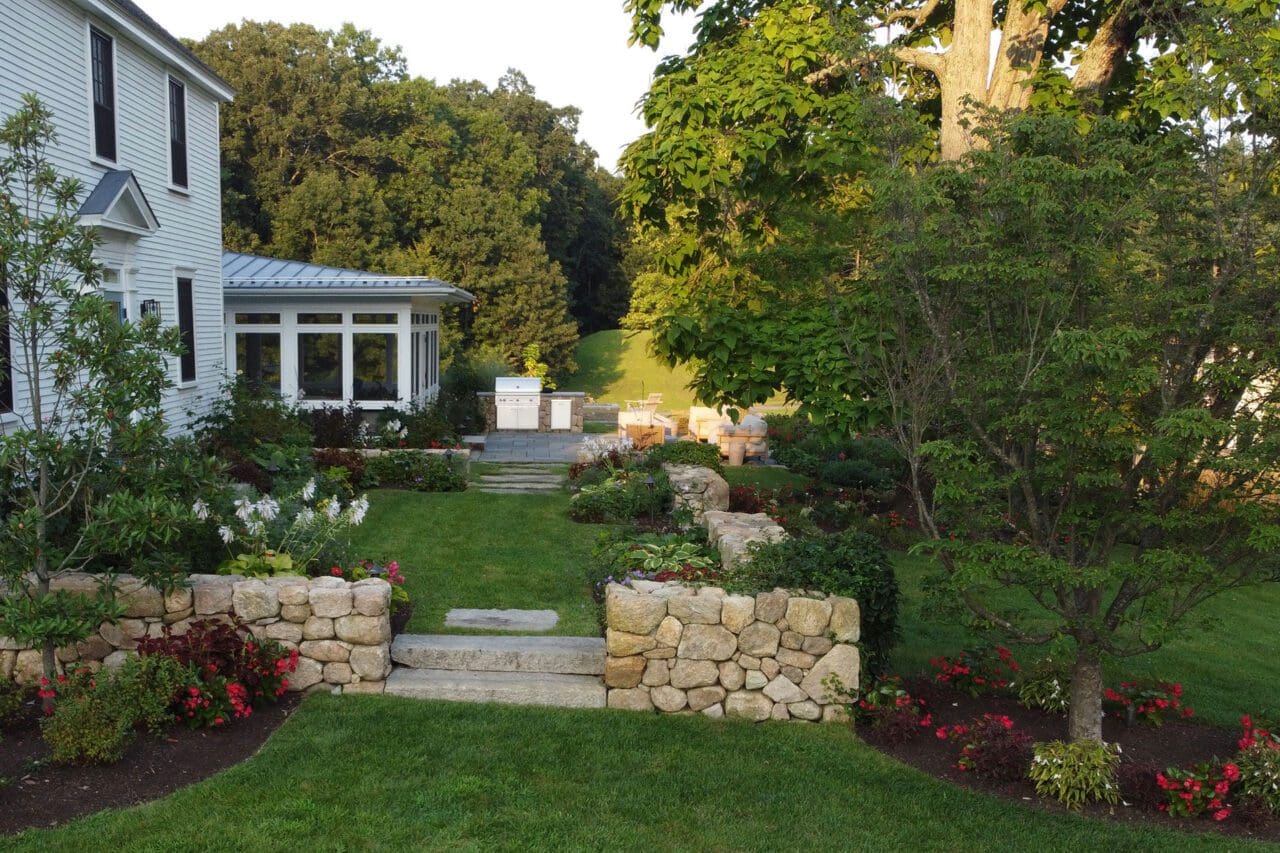 Raised garden beds and stone steps integrated with natural plantings, creating a functional and sustainable transition through the landscape.