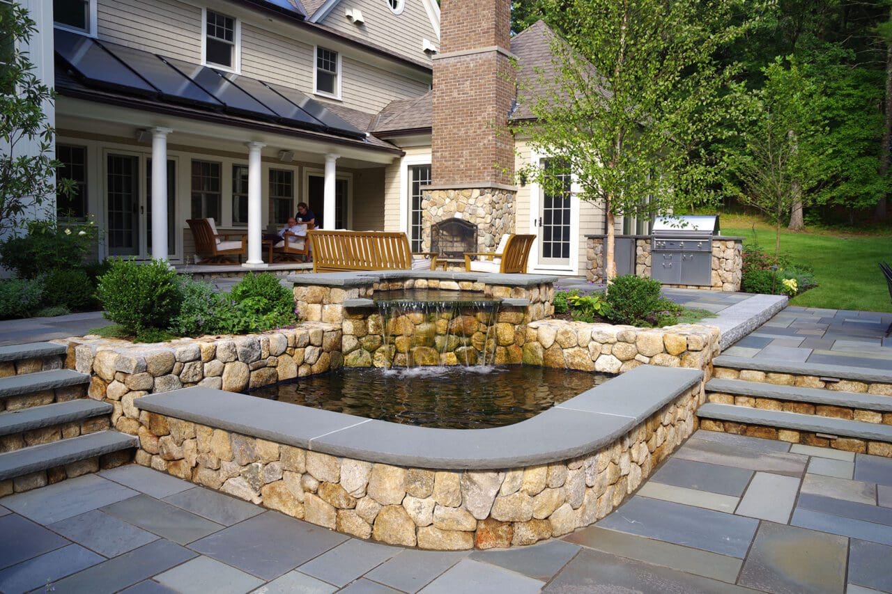 A thoughtfully integrated water feature adds gentle movement and sound to the outdoor living space, enhancing the atmosphere without overwhelming the surrounding landscape.