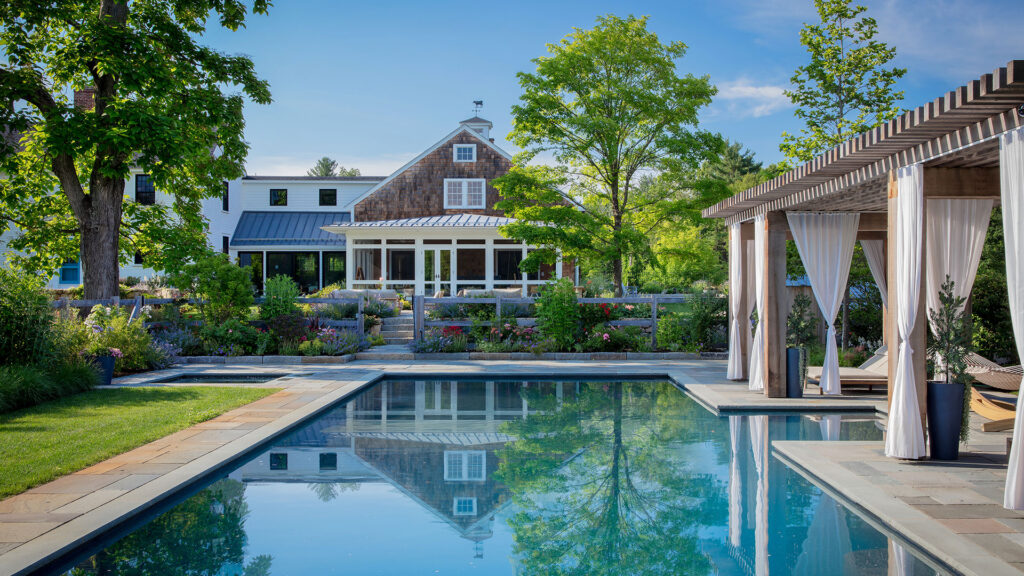 A cedar pergola anchors the pool terrace, reinforcing agrarian character while providing shade and structure. Photo: Michael J. Lee