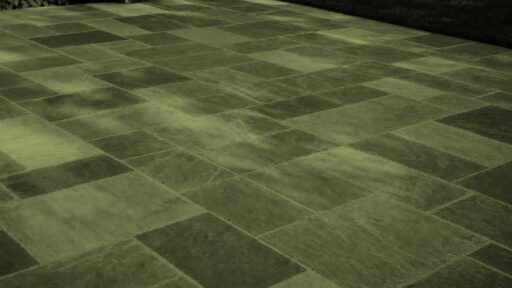 Belmont, MA - This dry-laid bluestone patio shows how frost heave, poor drainage, or an unstable base can cause individual stones to lift, sink, or rock after winter.