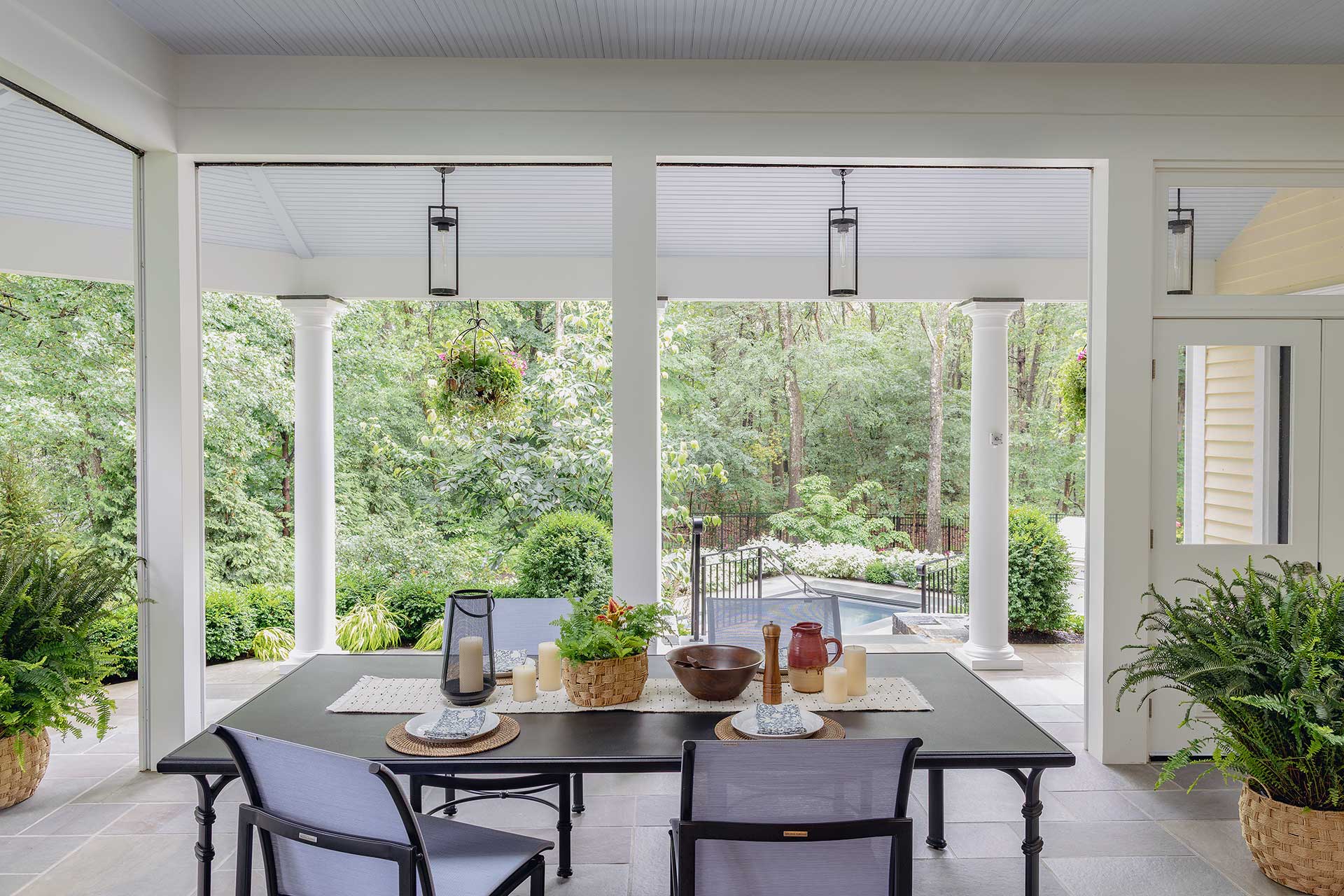 Fern plantings styled for a covered porch dining area, positioned for filtered light exposure and supported with routine watering and pruning for consistent health.