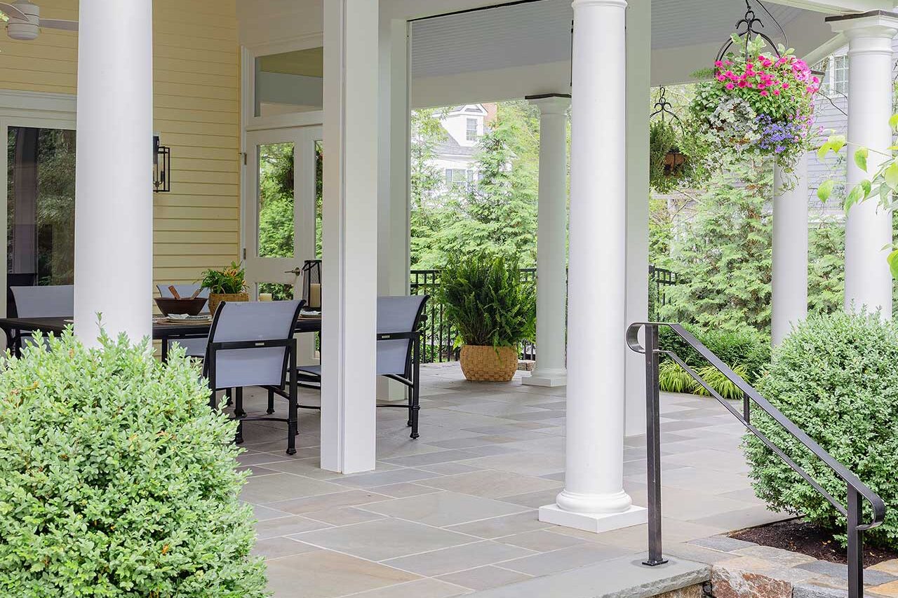 Stone steps, clean masonry, and clipped evergreen structure lead gracefully into the screened porch and connect the home to the broader landscape, copyright: Michael J Lee