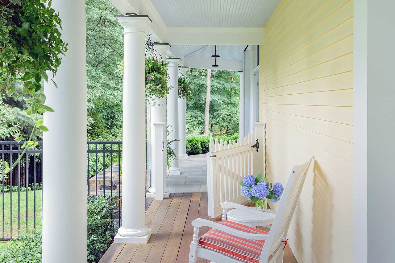 A covered side porch adds a quieter, more intimate edge to the property, with warm decking and garden views that extend the outdoor living experience, copyright: Michael J Lee