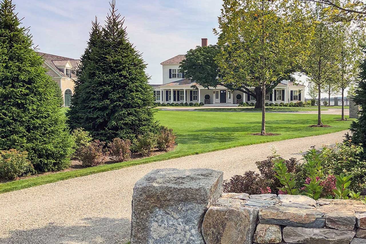 A natural stone patio and poolscape in Duxbury, MA, where layered plantings and clean hardscape lines create a relaxed outdoor living space suited to coastal Massachusetts properties.