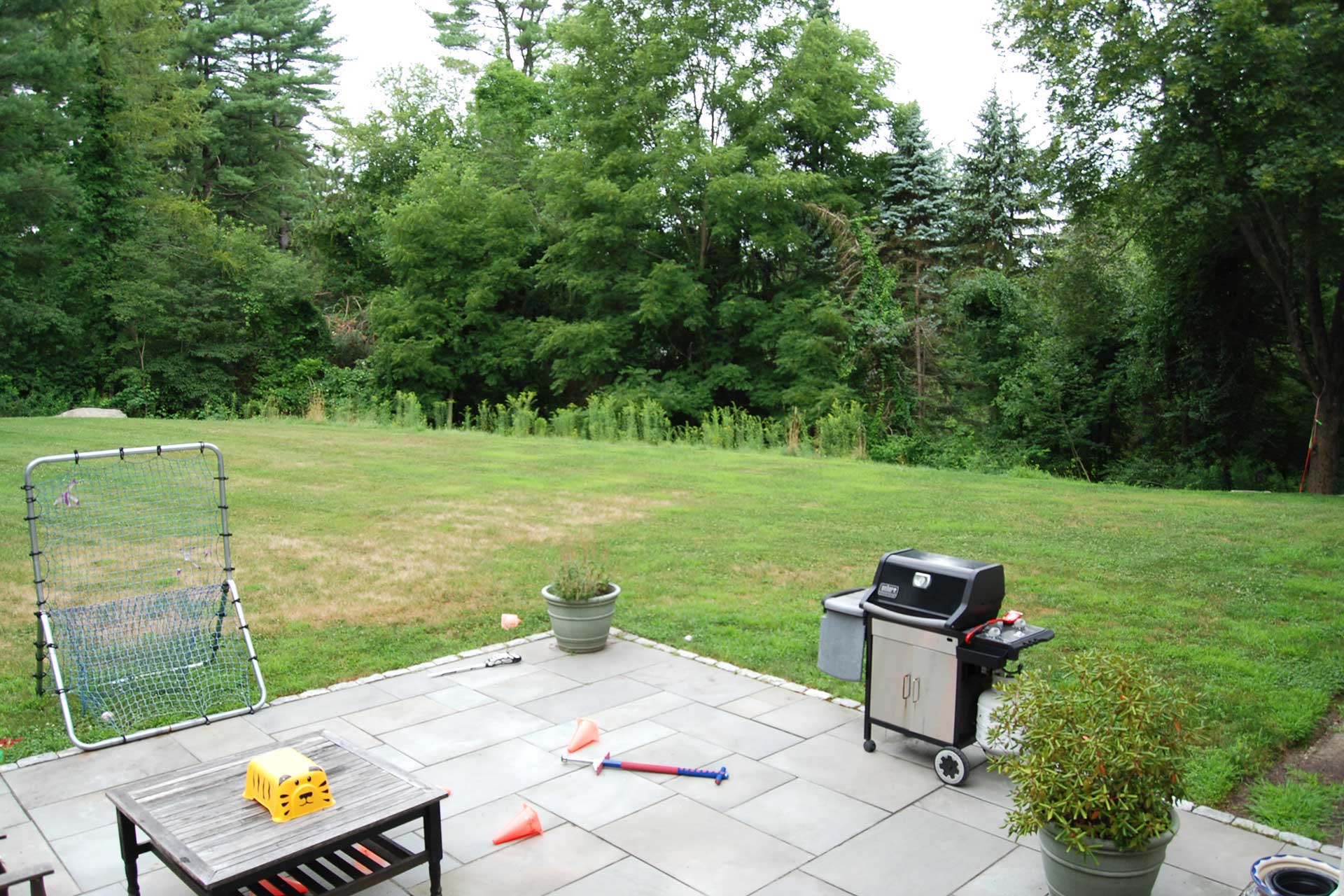 Before photo of Weston backyard with simple patio and lawn prior to landscape renovation