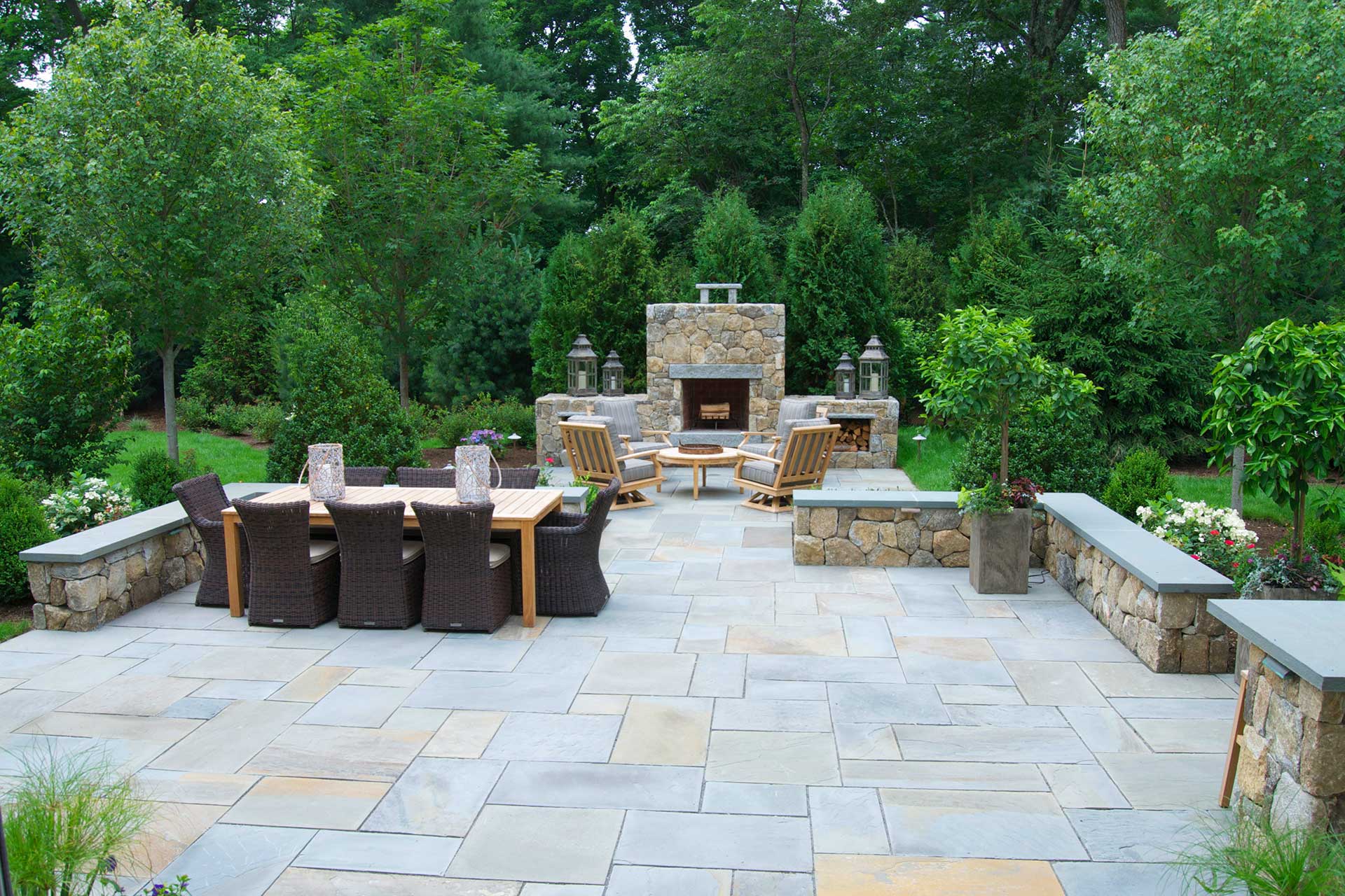 Weston backyard with stone patio, dining area, and outdoor fireplace