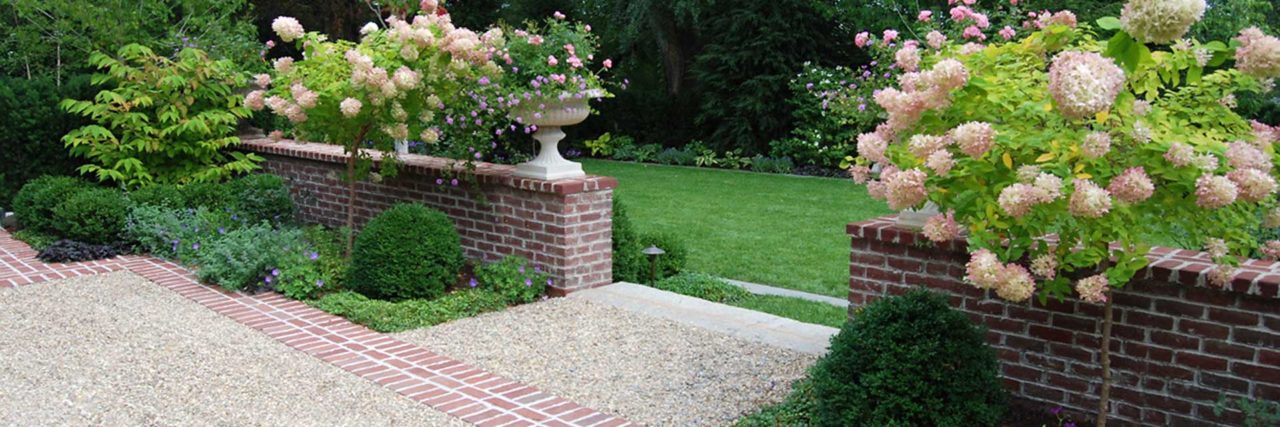 pea stone driveway with brick walls and planters