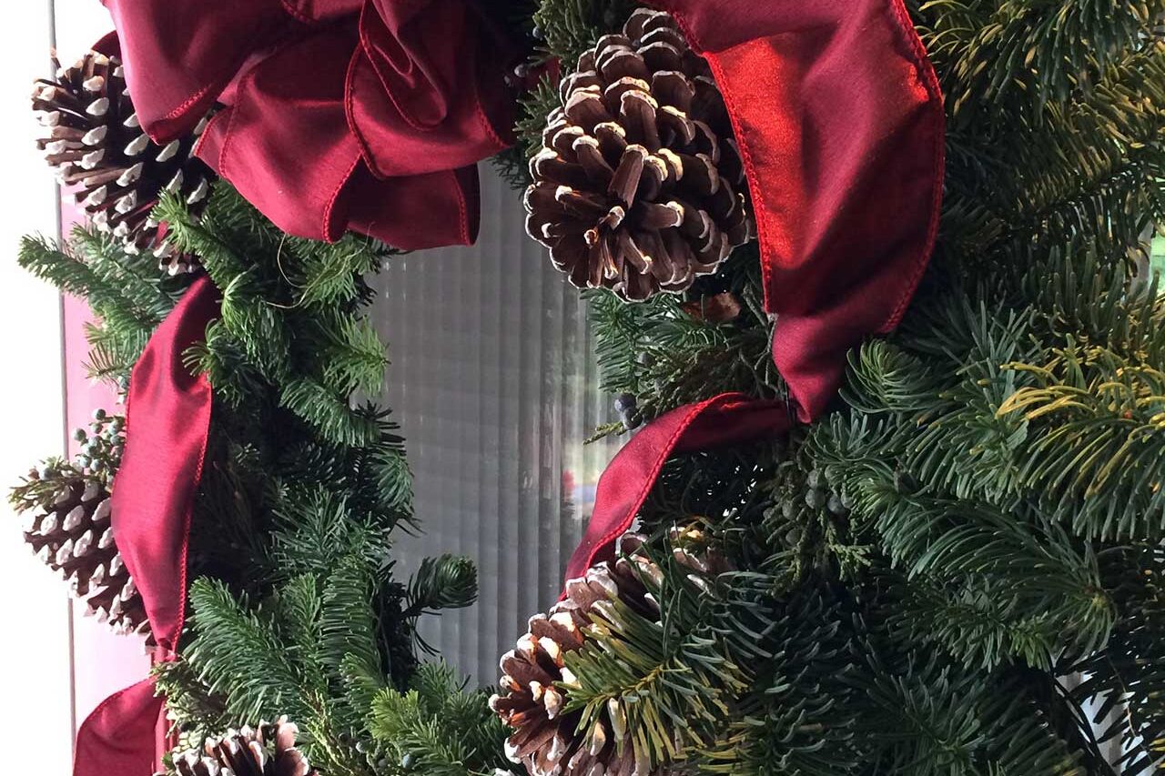 A simple Christmas wreath highlights the front door with natural greens, proving how a small detail can transform an entry.