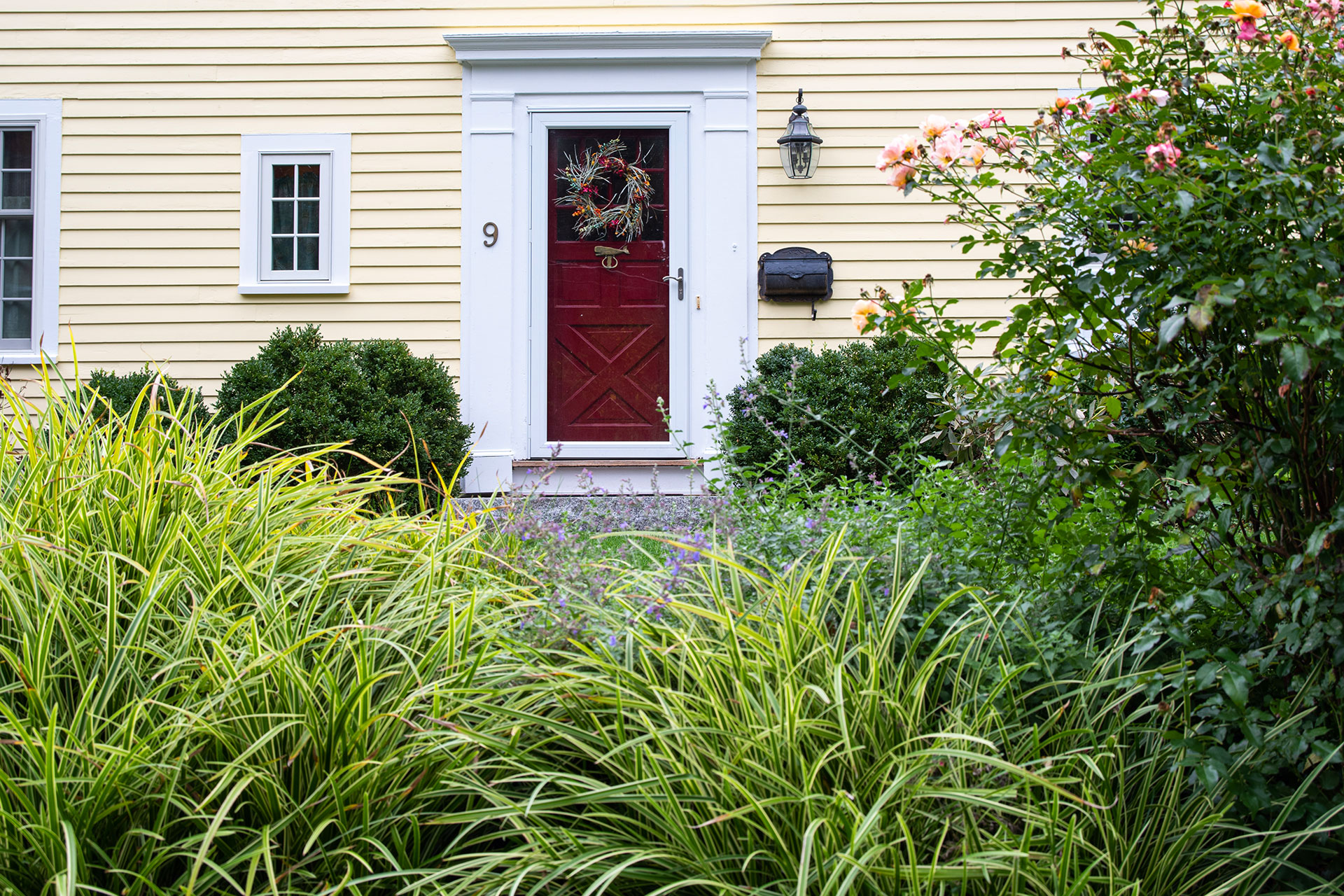 This wreath ties the entry garden to the home, using natural greens to add warmth and seasonal character with minimal effort.