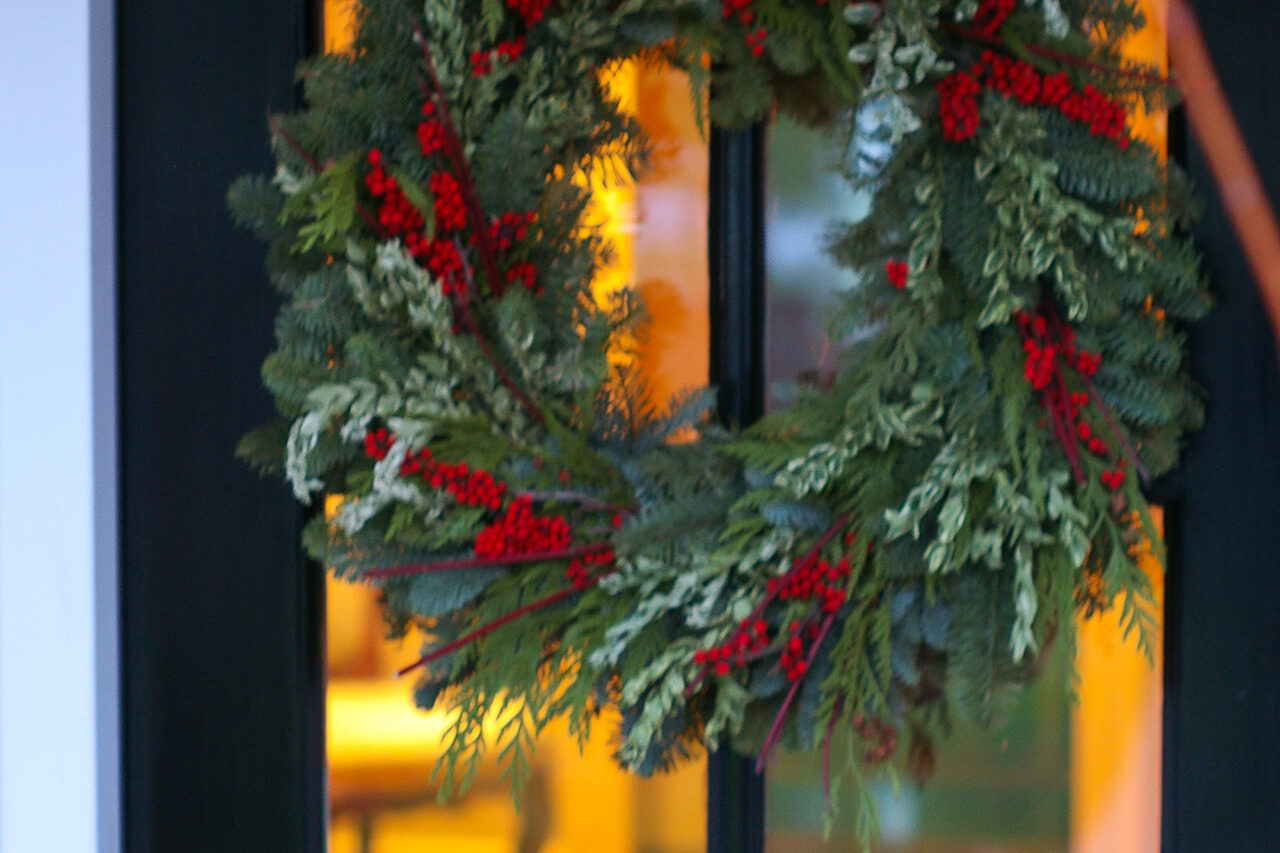Fresh-cut evergreens bring color, fragrance, and simple charm to the entryway, elevating curb appeal throughout the winter season.