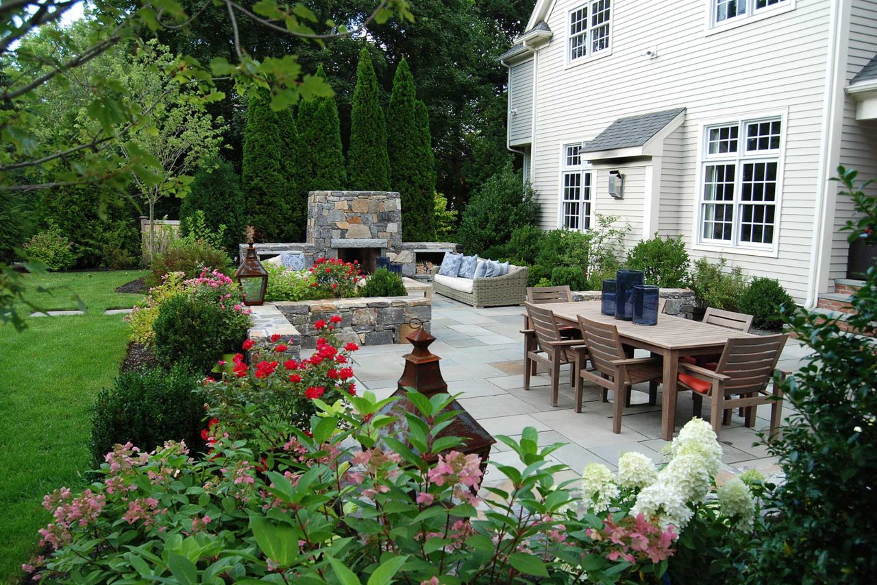 Dover, MA - Hydrangea, roses, and evergreen shrubs help define and soften the dining and fireplace areas.