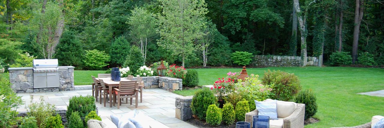 Dover, MA - A lush lawn contrasts stone surfaced dining and seating areas.