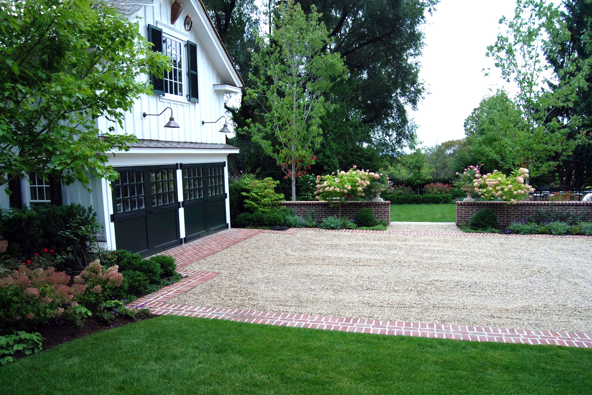 A gravel court driveway with brick borders forms a classic estate forecourt, offering generous turning space while reinforcing traditional materials and symmetry.