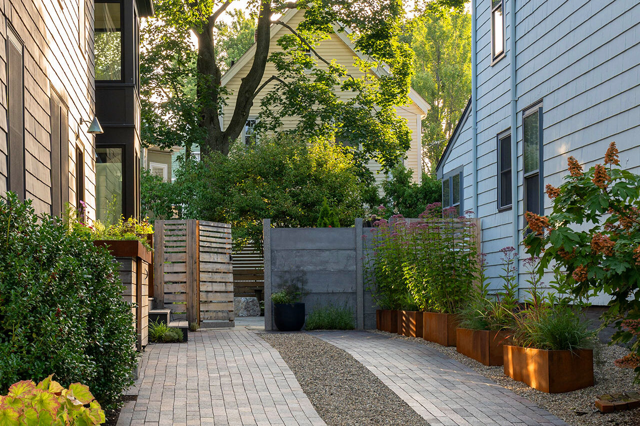 In Cambridge, MA, this modern paver driveway features gravel inlay for texture and contrast, combining crisp lines with permeability and a contemporary architectural feel.