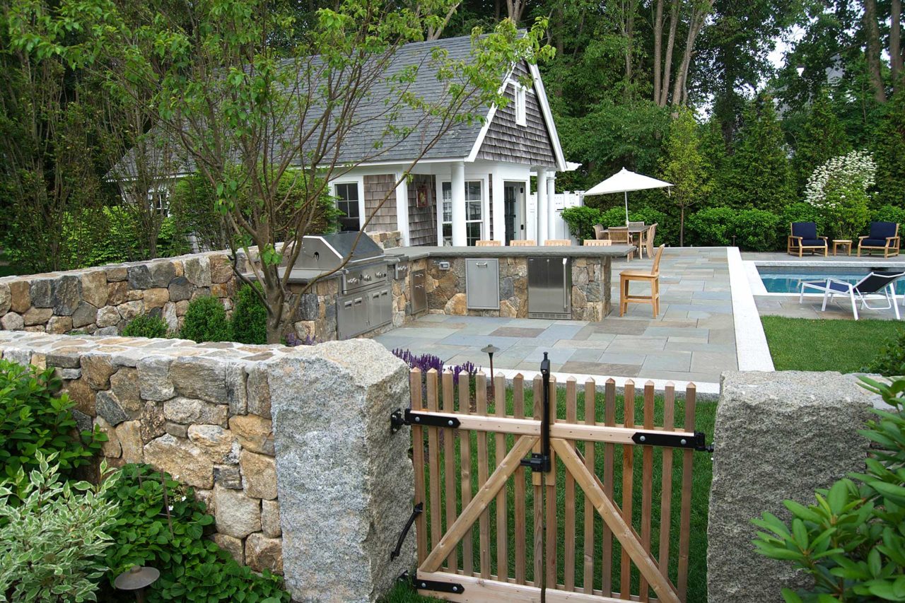 Duxbury, MA - Granite posts mark the entrance to the outdoor kitchen, bluestone patio, and pool area.