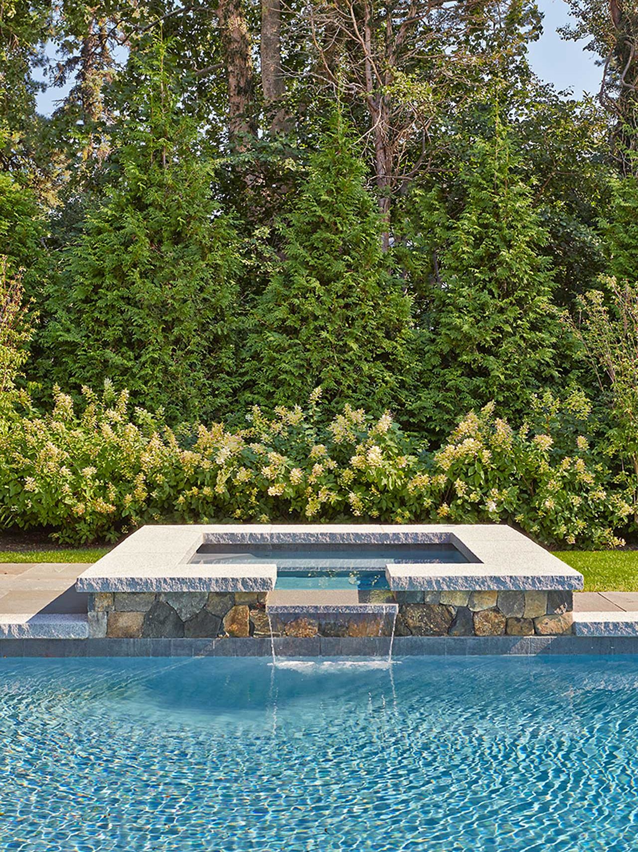 Duxbury, MA - An inviting spa integrated with the pool and backed by lush hydrangeas and screening arborvitaes.