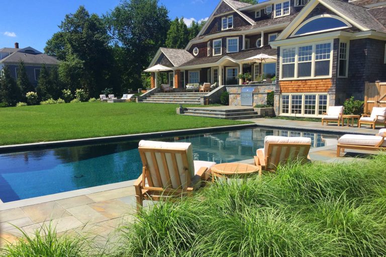 Duxbury, MA - A backyard retreat complete with an in ground pool, lush lawn and plantings, bluestone surfaces, and a built in kitchen.