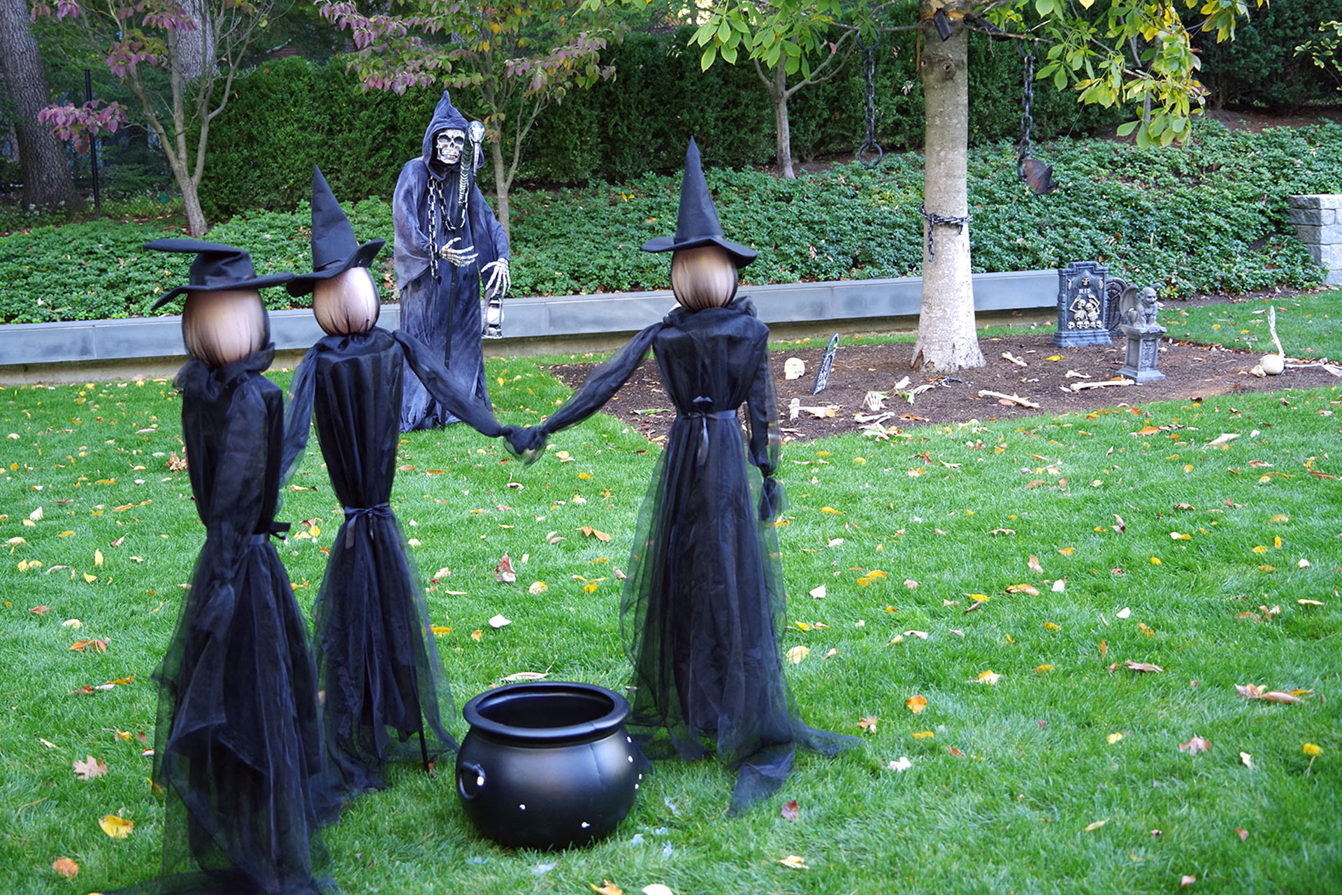 A playful Halloween lawn scene features a witches’ cauldron and seasonal props, creating family-friendly wow factor while showing how themed displays can transform a yard.