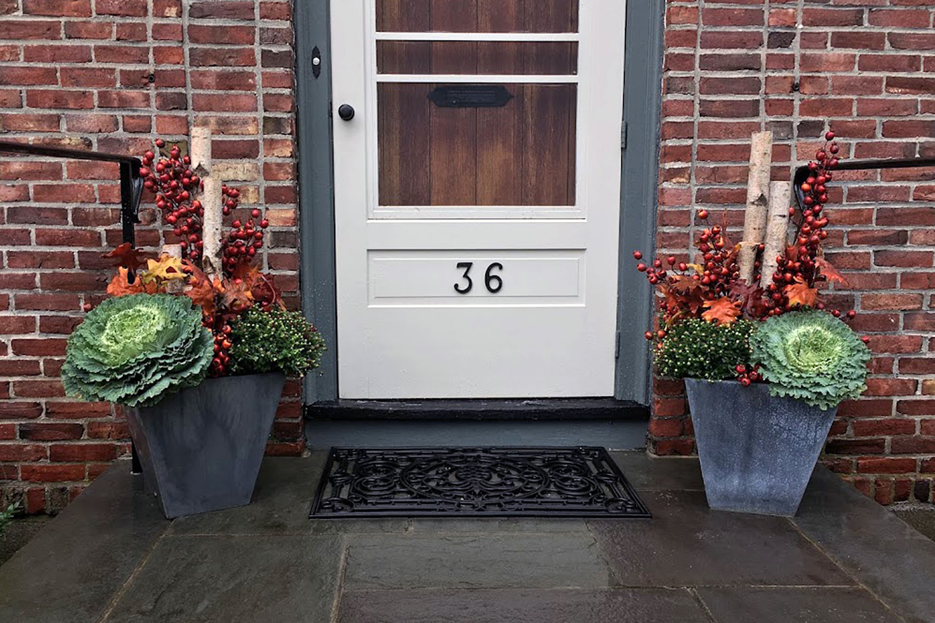 Wellesley, MA entry planters featuring ornamental cabbage, red berries, and birch branches deliver bold symmetry and customizable autumn style.