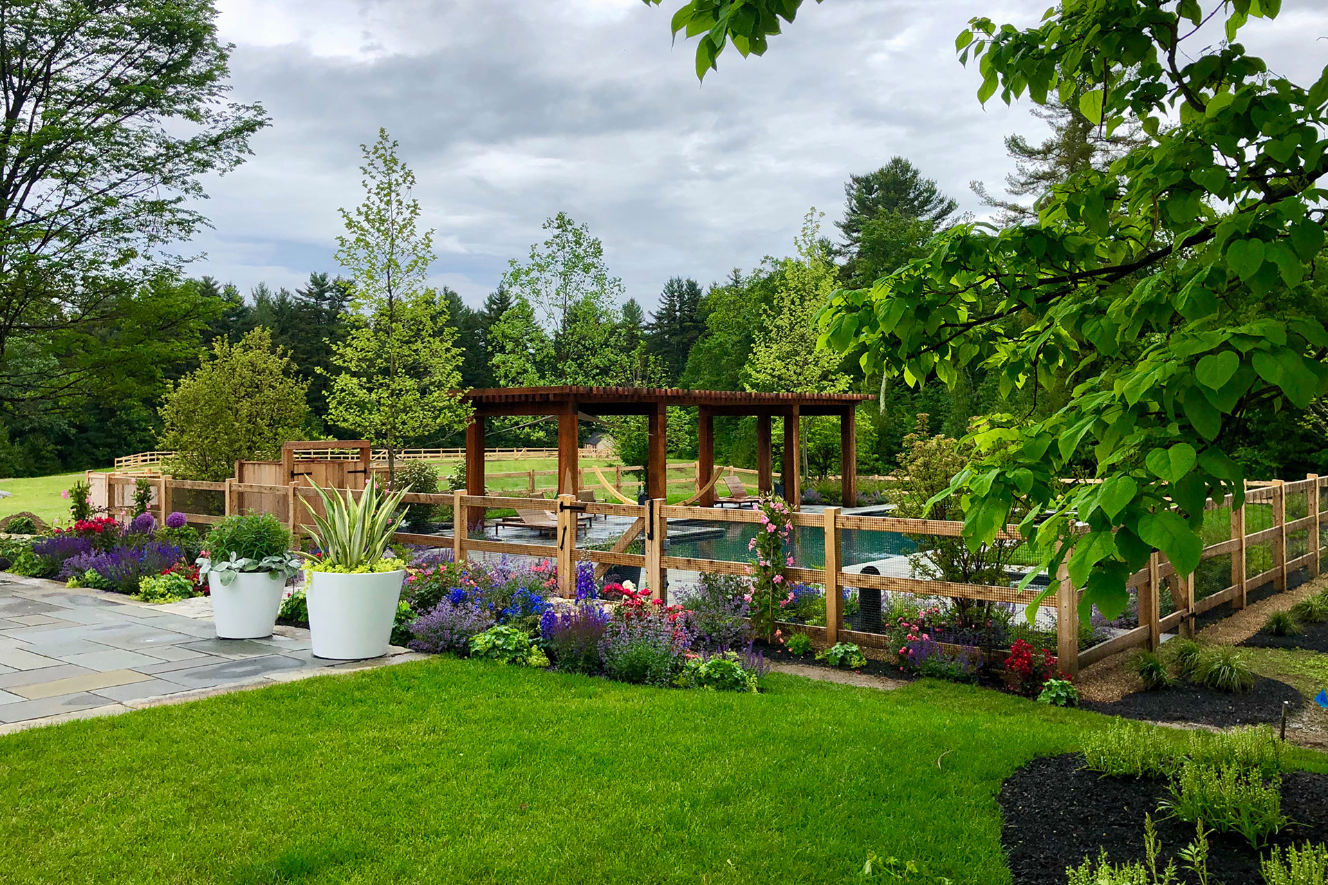 This cedar fence establishes a defined garden boundary, using an integrated gate to guide entry and control access without disrupting circulation.