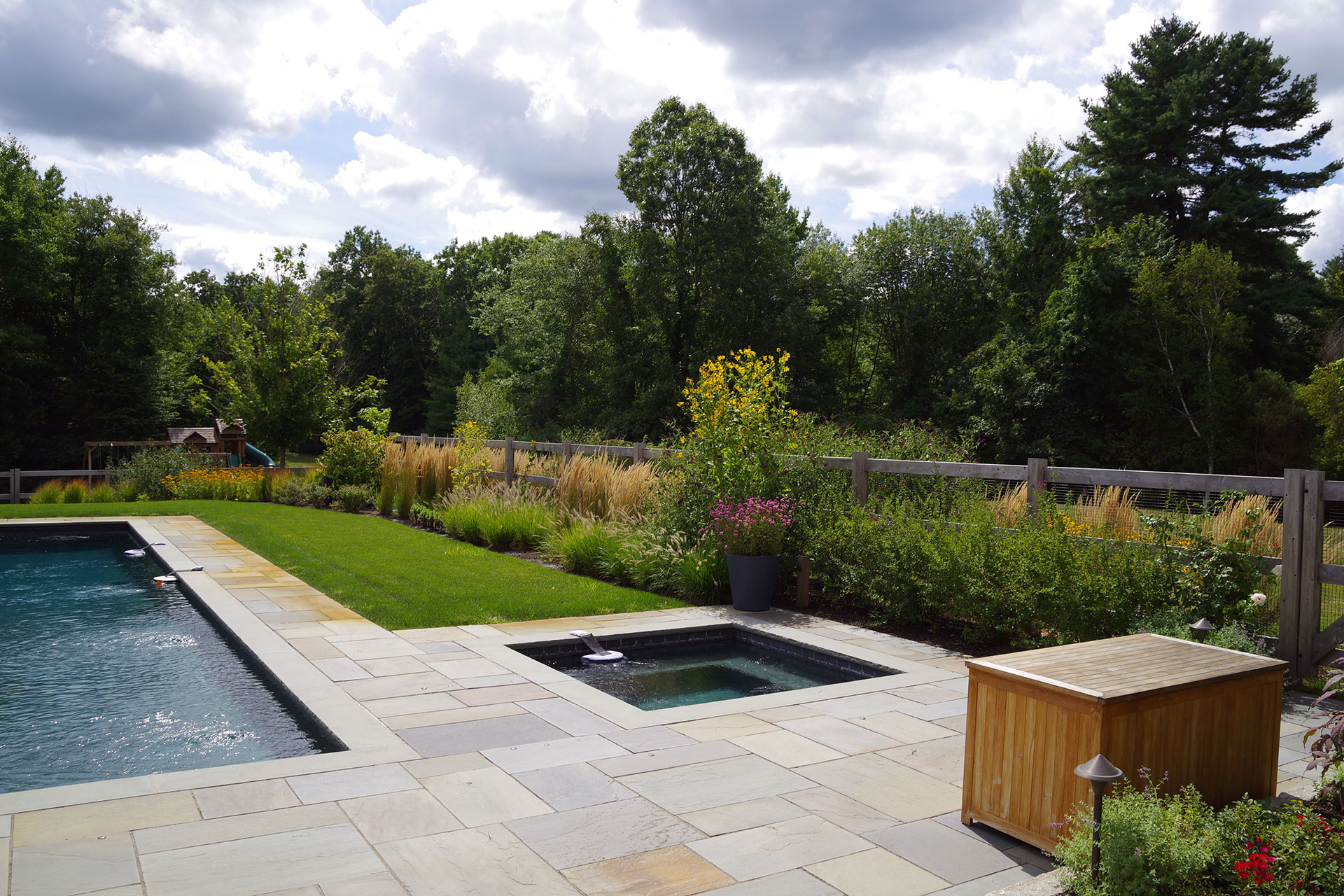 Horizontal wood fencing enhances pool safety while reinforcing a modern, streamlined look across the landscape.