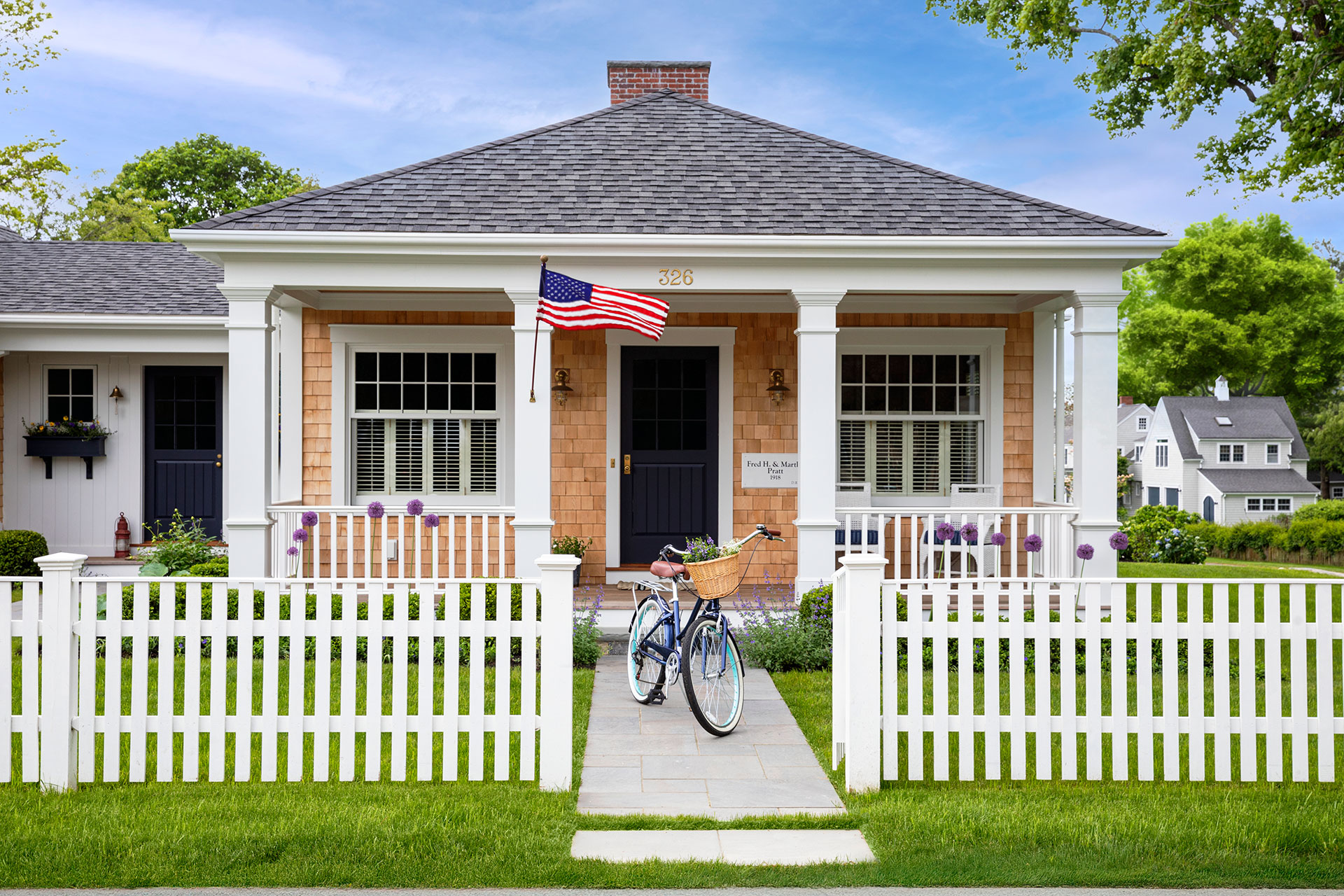 This white picket fence reinforces cottage character, creating a welcoming boundary that keeps gardens organized and visually inviting.