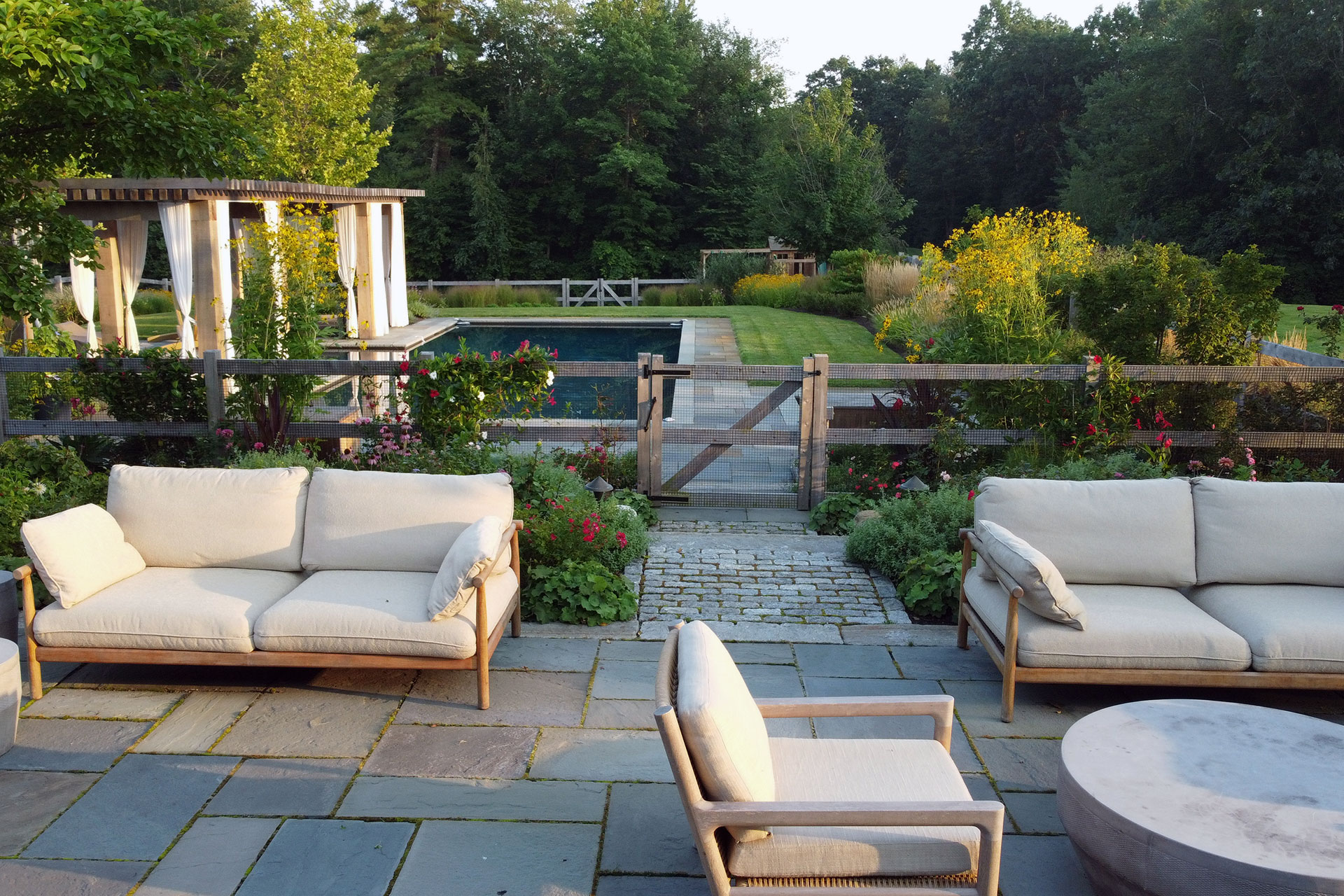 atural wood pool fencing blends with native plantings, creating a safe enclosure that protects children and pets without interrupting backyard views.