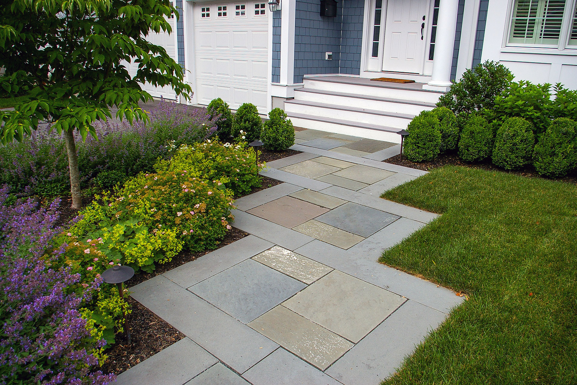 Cut bluestone walkway features crisp lines and a modern layout, elevating front entry design in Wellesley.