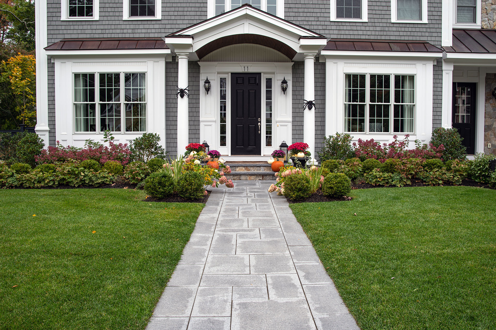 Bluestone front entry walk framed by symmetrical planting reinforces balance, order, and classic curb appeal.
