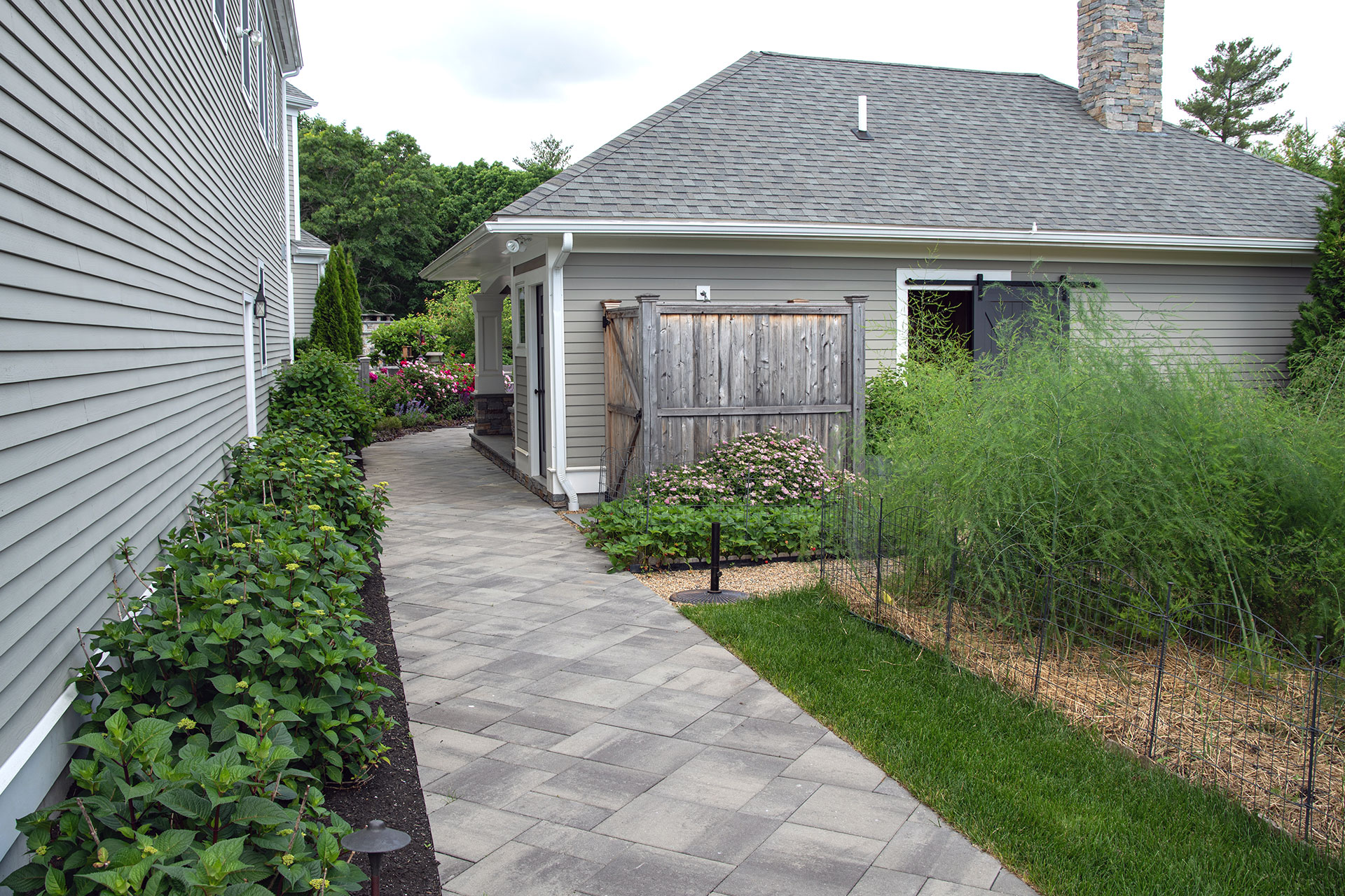 Gray concrete paver service walk offers a clean, practical side-yard route with durability and low maintenance.