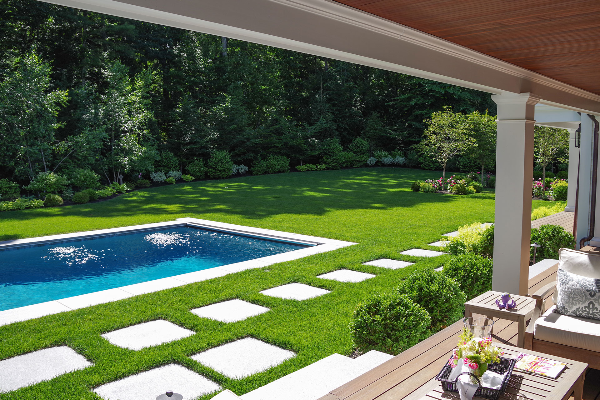 Large stepping stones set into lawn provide clean, modern circulation while preserving open green space and minimizing hardscape footprint.